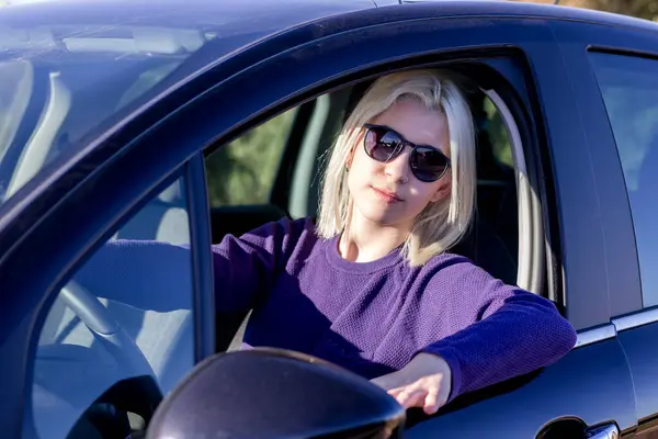 Blonde Woman Sunglasses Sitting Confidently Steering Wheel Car Portraying Leisure Stockfoto