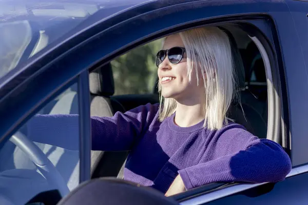 Αυτοπεποίθηση Ξανθιά Γυναίκα Χαμογελά Κατά Την Οδήγηση Του Αυτοκινήτου Της Εικόνα Αρχείου