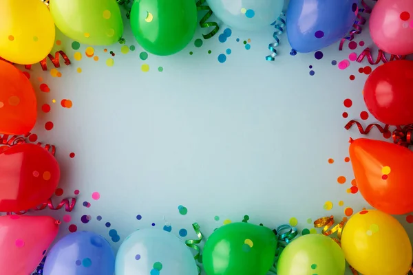 Birthday party background with rainbow border of colorful party balloons with streamers and confetti