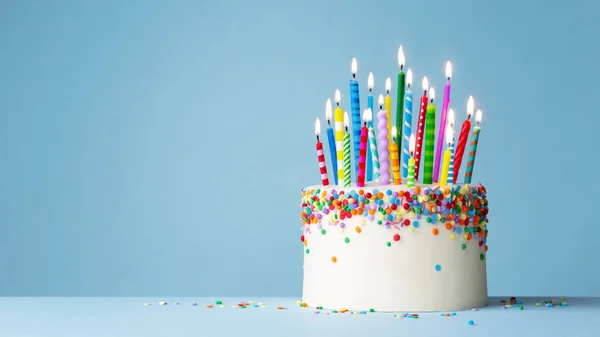 カラフルなスプリンクルと21のカラフルな誕生日キャンドルでお祝いの誕生日ケーキ — ストック写真
