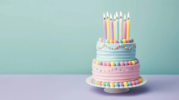 用糖果和色彩艳丽的蜡烛装饰的面糊色层次分明的生日蛋糕 白色的奶油在浅绿色的背景下结霜 — 图库照片