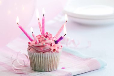 Altı pembe mumla süslenmiş kek, doğum günü partisi için hazır.