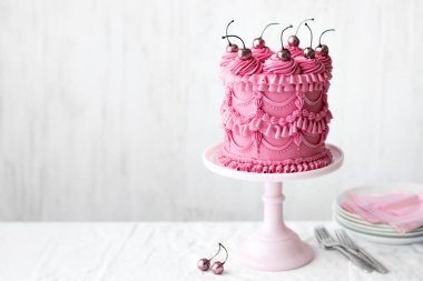 Pembe kutlama pastası, kremalı, fırfırlı ve vişneli.