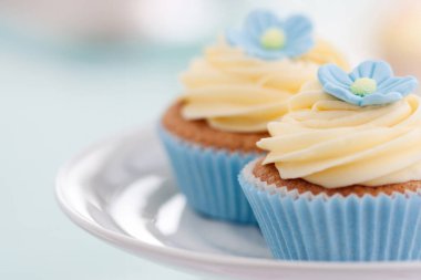 Mavi şeker çiçeklerle süslenmiş cupcakes