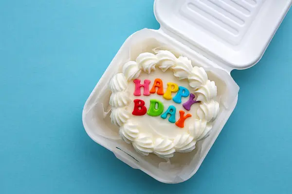 小生日蛋糕 纸盒里有五彩缤纷的生日祝词 免版税图库图片