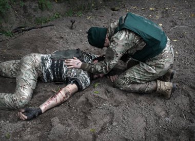 A.B.D. Nato Muhafız Birliği Ekibi acı erkek polis memuru silah yarası tehlikeyi korumada yardım et savaş karanlık alana düş sağlık görevlileri yardım çığlıkları yaralanmaya yardım et kan kaybeden savaşçı kahraman