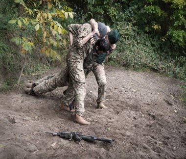 A.B.D. Nato birliği, kolluk muhafızı, erkek, el tabancası yaralanmış. Kan, umut, acı, hayat, karanlık orman, ağaç tarlasıyla mücadele. İnsan yardımcıları kahramanları ölüm şokunu yaşadılar umutsuzluğa düştüler