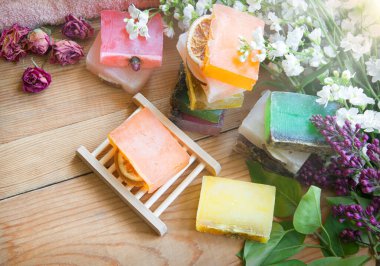 Taze eko çiçekli, yağlı el, gül kokusu, durulama, ahşap el işi, yazı masası zemininde durulandı. Birçok ıslak su kuyusu köpük sembolü güzellik hediyesi eski moda sanat tasarımı stili rahatla