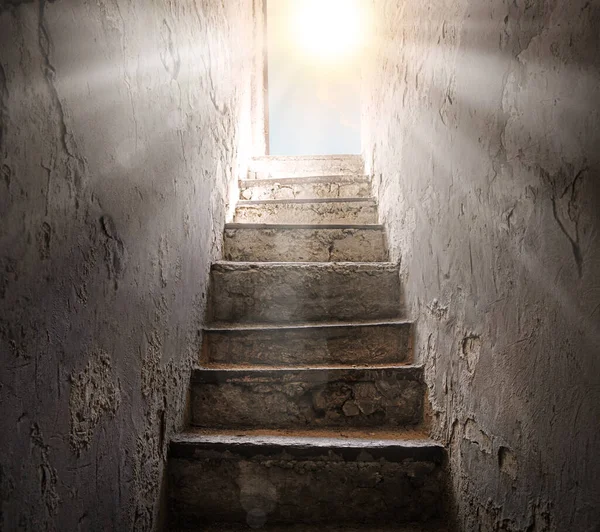 浅白的光芒照射在锈迹斑斑的堡垒上 困住了历史墓穴下的监狱大厅 面带微笑的铅爬上高高的台阶向上爬上梯子箱门的目的是点亮昏暗的日光天希望的概念背景 — 图库照片