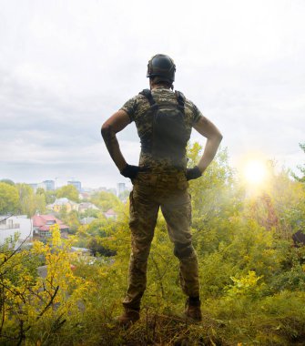 Yalnız, yorgun, genç, ABD 'li, NATO' lu erkek, dinleniyor. Kalça bel, bak. Tehlike ormanı, ağaç ışığı, beyaz gökyüzü mesaj sahası. Yalnız üzgün üzgün üzgün üzgün üzgün hisset. Kayıp veteriner kahraman tanrı inancı kavramı.