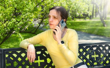 Yetişkin, genç ve güzel bir bayan neşeli bir gülümseme zihinsel çalışma modundaki koltuğu hisset eski moda sandalye yeşil çim çim bahçesi mesaj alanı. Aşk yüzü üzgün görünüyor bekle rüyayı dinle, eğlen ve dinlen.