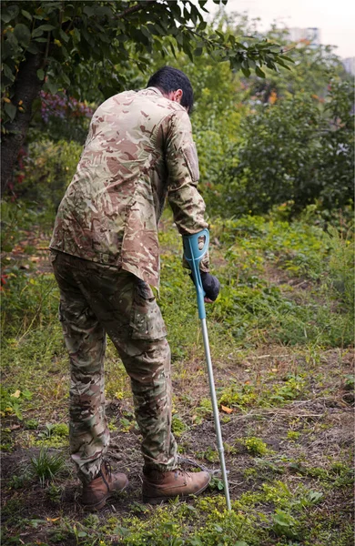 Stock image Russia army force guard stress pain guilt think young male guy camo uniform foot leg protect go fall park yard field Lone human cry god care arm bone invalid failure vet warrior fighter hero back view