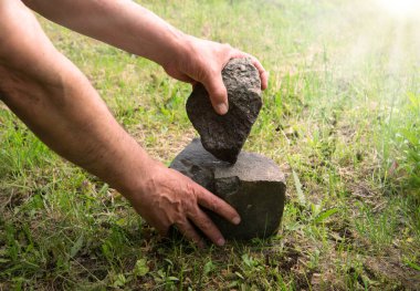 Habilis erectus çıplak çocuk heykeltraş palmiyesi sanat eseri becerisi yaptı sert sert bazalt kaya kozalakları toprak toprak toprak metin alanı. Geçmiş çağ antik çağı. İlkel göçebe hayatta kalır. Aktif sembol olur.