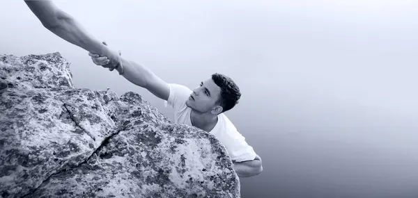 リスクの高い若いアルピニストのジョブリーダーの男統一アームケアは 湖の海の川を望む神の信頼を高めようとします ハング女性は助けを求める 生命の転落危機 努力を上げる 勝利は丘の上のピークを克服 深いギャップの空の太陽 — ストック写真