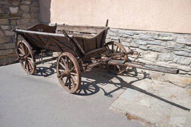 Eski, boş, kahverengi, avrupa malı el arabası sahne aydınlatma evi duvarlı mesaj alanı. Yakın plan manzaralı Asyalı çingene tarzı büyük telga arabası Rim, Batı Asya turist yolu çizim tabelasıyla konuştu.