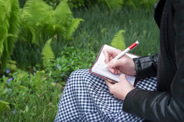 Kapat görünümü akıllı yazar boş sayfa çalışma notları boş sayfa orman yeşili çimen bahçesi alanı yakın çekim gençlik gençlik ders kolu tutuş kalem resim çizimi açık kart öğret