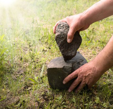 Habilis erectus çıplak çocuk heykeltraş palmiyesi sanat eseri becerisi yaptı sert sert bazalt kaya kozalakları toprak toprak toprak metin alanı. Geçmiş çağ antik çağı. İlkel göçebe hayatta kalır. Aktif sembol olur.