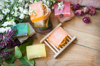 Taze eko çiçekli, yağlı el, gül kokusu, durulama, ahşap el işi, yazı masası zemininde durulandı. Birçok ıslak su kuyusu köpük sembolü güzellik hediyesi eski moda sanat tasarımı stili rahatla