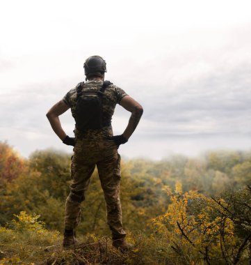 Yalnız, yorgun, genç, ABD 'li, NATO' lu erkek, dinleniyor. Kalça bel, bak. Tehlike ormanı, ağaç ışığı, beyaz gökyüzü mesaj sahası. Yalnız üzgün üzgün üzgün üzgün üzgün hisset. Kayıp veteriner kahraman tanrı inancı kavramı.