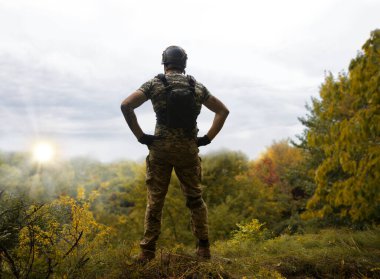 Yalnız, yorgun, genç, ABD 'li, NATO' lu erkek, dinleniyor. Kalça bel, bak. Tehlike ormanı, ağaç ışığı, beyaz gökyüzü mesaj sahası. Yalnız üzgün üzgün üzgün üzgün üzgün hisset. Kayıp veteriner kahraman tanrı inancı kavramı.