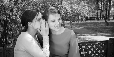 İki güzel yetişkin bayan, yaz kenti şehir merkezindeki ağaçlık alanda yalan söylüyor. Gençlik ilişkisi yalancısı. Bak, neşeli neşe şoku. Gülümse.