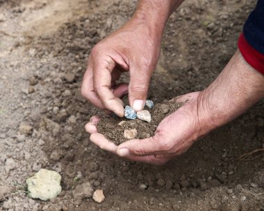 Eski köylü işçi palmiyesi, yakın plan kırsal yaşam hazırlık. Küçük tanecikler, bereketli çamur humus toprak tozu toprak bakımı hobisi. Ayrıntılı görünüm kol çalışma kum yığınları iyi görünüyor ekoloji umut kavramı