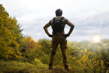 Yalnız, yorgun, genç, ABD 'li, NATO' lu erkek, dinleniyor. Kalça bel, bak. Tehlike ormanı, ağaç ışığı, beyaz gökyüzü mesaj sahası. Yalnız üzgün üzgün üzgün üzgün üzgün hisset. Kayıp veteriner kahraman tanrı inancı kavramı.
