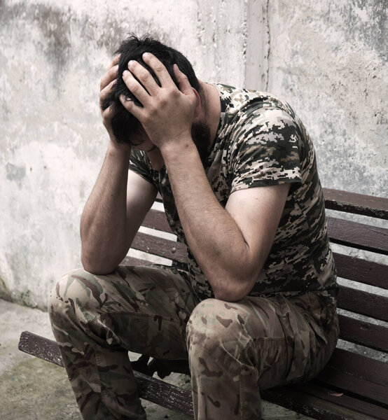 Уставший патриот ВМС США сидит на старой скамейке и защищает городскую стену города от опасности. Беспокойство боль в голове человека крик руки чувствовать расстроен поражение потерянный герой вера Бога духовная концепция