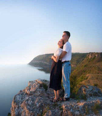 2 genç taşralı erkek, neşe dolu bir eğlence istirahatı için güneşli bir ortama bakıyor. Mutlu gülümseme bayan yürüyüşçü el ele tutuşun barış okyanus yürüyüşü kaya tepesi sahnesine tırmanın