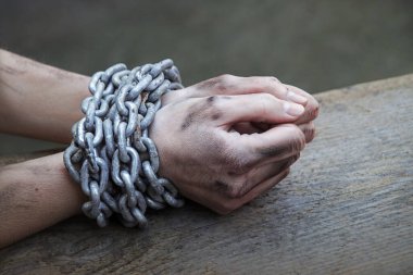 Yakın görüş eski kanun tehlikesi. Stresli erkek çocuk Tanrı 'dan yaşam ahşap metin uzayına yardım etmesini diliyor. Kapanış limiti, acı, kadın bileğini bağlıyor. Demir halat, vücut istismarını engelliyor.