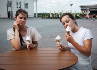 2 genç, mutlu, neşe dolu, neşeli bayan çocuk, kaşlarını çatmış, tatlı, lezzetli, fast food diyeti negatif, kızgın, kavgacı, şüpheci, komik, huysuz, yargıcı, emot alışkanlığı sorunu olan bir park yeri.