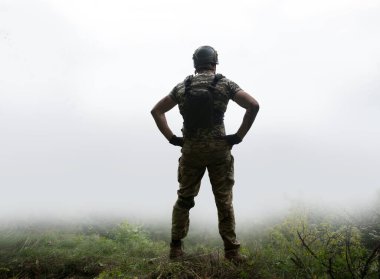 Yalnız, yorgun, genç, ABD 'li, NATO' lu erkek, dinleniyor. Kalça kemiğinde umut var. Sis bulutu, duman bulutu, gökyüzü mesaj alanı.