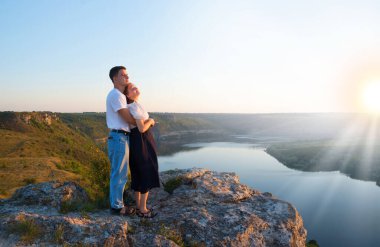 2 genç taşralı erkek, neşe dolu bir eğlence istirahatı için güneşli bir ortama bakıyor. Mutlu gülümseme bayan yürüyüşçü el ele tutuşun barış okyanus yürüyüşü kaya tepesi sahnesine tırmanın