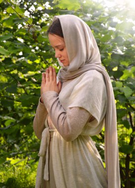 Yalnız, kutsal, genç, üzgün Doğu Yahudi Mary eski, eski püskü şal peçesi diz çök, çim biçen el, İsa 'ya dua et. Kırsal kesimdeki genç kız. Neşeli kız. Şükürler olsun.