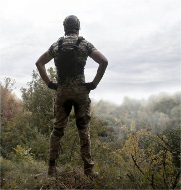 Yalnız, yorgun, genç, ABD 'li, NATO' lu erkek, dinleniyor. Kalça bel, bak. Tehlike ormanı, ağaç ışığı, beyaz gökyüzü mesaj sahası. Yalnız üzgün üzgün üzgün üzgün üzgün hisset. Kayıp veteriner kahraman tanrı inancı kavramı.