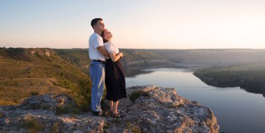 2 genç taşralı erkek, neşe dolu bir eğlence istirahatı için güneşli bir ortama bakıyor. Mutlu gülümseme bayan yürüyüşçü el ele tutuşun barış okyanus yürüyüşü kaya tepesi sahnesine tırmanın