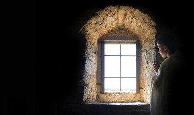 Genç üzgün, üzgün, endişeli, Yahudi, insan suratlı, Tanrı 'ya dua et de rüya aşkı dile. Genç bayan, siyah hapishane kalesinin duvarında duruyor. Korku, acı, üzüntü, savaş, mesaj alanı.