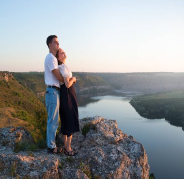 2 genç taşralı erkek, neşe dolu bir eğlence istirahatı için güneşli bir ortama bakıyor. Mutlu gülümseme bayan yürüyüşçü el ele tutuşun barış okyanus yürüyüşü kaya tepesi sahnesine tırmanın