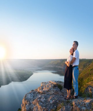 2 genç taşralı erkek, neşe dolu bir eğlence istirahatı için güneşli bir ortama bakıyor. Mutlu gülümseme bayan yürüyüşçü el ele tutuşun barış okyanus yürüyüşü kaya tepesi sahnesine tırmanın