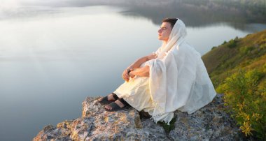 Kırsal barış, günbatımında güneş batımında tek neşeli genç yahudi çocuk David yaşlı peçe, umarım Tanrı İsa Mesih 'in inancı üzerine oturur. Vahşi Yahudi parkı ağacı üzgün deniz havuzu okyanus kızı manzaralı eski İncil 'e ait metin alanı