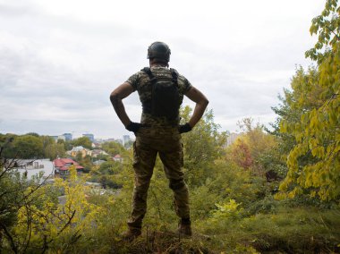 Yalnız, yorgun, genç, ABD 'li, NATO' lu erkek, dinleniyor. Kalça bel, bak. Tehlike ormanı, ağaç ışığı, beyaz gökyüzü mesaj sahası. Yalnız üzgün üzgün üzgün üzgün üzgün hisset. Kayıp veteriner kahraman tanrı inancı kavramı.