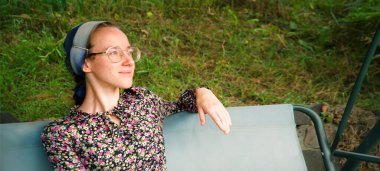 Yetişkin, yaşlı, güzel, yorgun, el elbisesi giysili kadın kederli yas stresi üzerine kafa yoruyor. Ruh hali, eski koltuk, yeşil çimen güneş mesaj alanı. Kayıp aşk gözü, dua et, neşe dolu yüz, bak, neşeli Tanrı inancı.