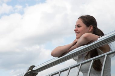 Yetişkin, sevimli, dindar bir bayan gülümsüyor, dua ediyor, dua ediyor, mutlu mesut mutlu oluyor, Avrupa 'nın beyaz ev manzarasını seyrediyor. Sadece sevgi göz eğlence yürüyüş görmek anne inanmak Tanrı inanç modern park veranda demiryolu yalan