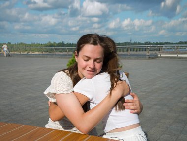 İki yetişkin bayan, el ele tutuşup ağlar ve şehrin yaz kenti kafeterya masasının dışında güneşli havadan sudan konuşurlar. Gençler kendilerini iyi hissederler. Hüzün, üzüntü, üzüntü, neşe, güven, güven, inanç krizi.