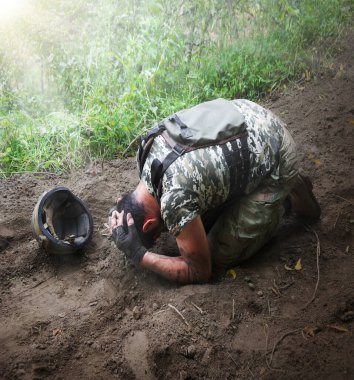 Tek başına yorgun ABD vatanseverlik birliği erkek adam diz çöküp el pençe divan duruyor. Tehlike sonrası acı veren karanlık orman ağacı çalı mesaj alanı. Tek endişem, insan ağlaması. Kaybolmuş tıbbi kahraman Tanrı inancı kavramı.