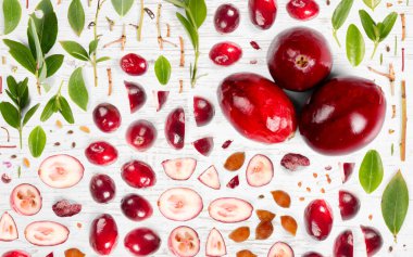 Kızılcık meyvesi, dilimleme ve yaprak koleksiyonu. Düz, pürüzsüz soyut arkaplan.