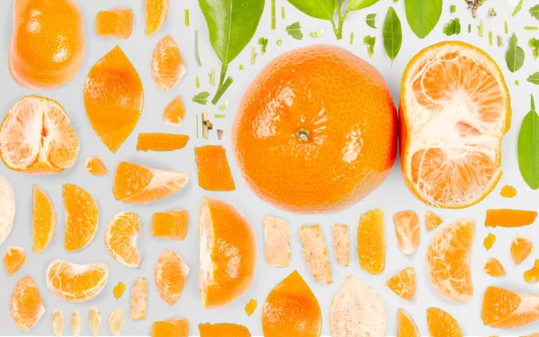 タンジェリンの果実片 スライス 葉からなる抽象的な背景は灰色の背景に隔離されている — ストック写真