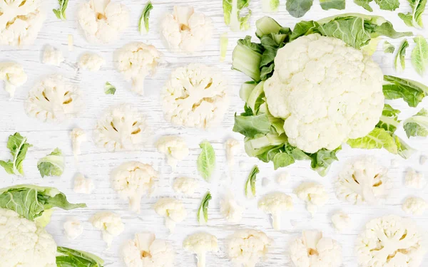 Abstrakter Hintergrund Aus Blumenkohl Gemüsestücken Scheiben Und Blättern Auf Holzgrund — Stockfoto