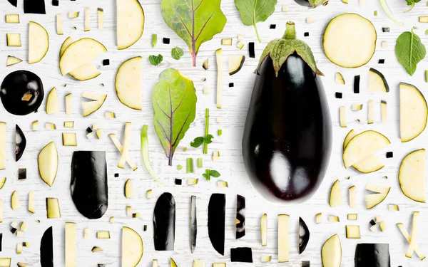 Abstrakter Hintergrund Aus Auberginen Gemüsestücken Scheiben Und Blättern Auf Holzgrund — Stockfoto