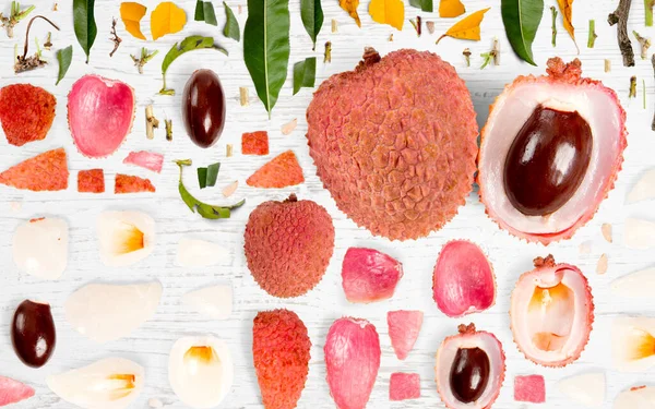 Abstrakter Hintergrund Aus Litchi Fruchtstücken Scheiben Und Blättern Auf Holzgrund — Stockfoto